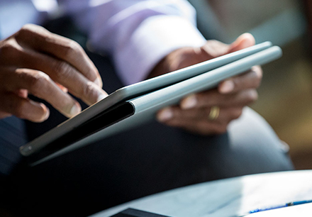 man holding and working on tablet